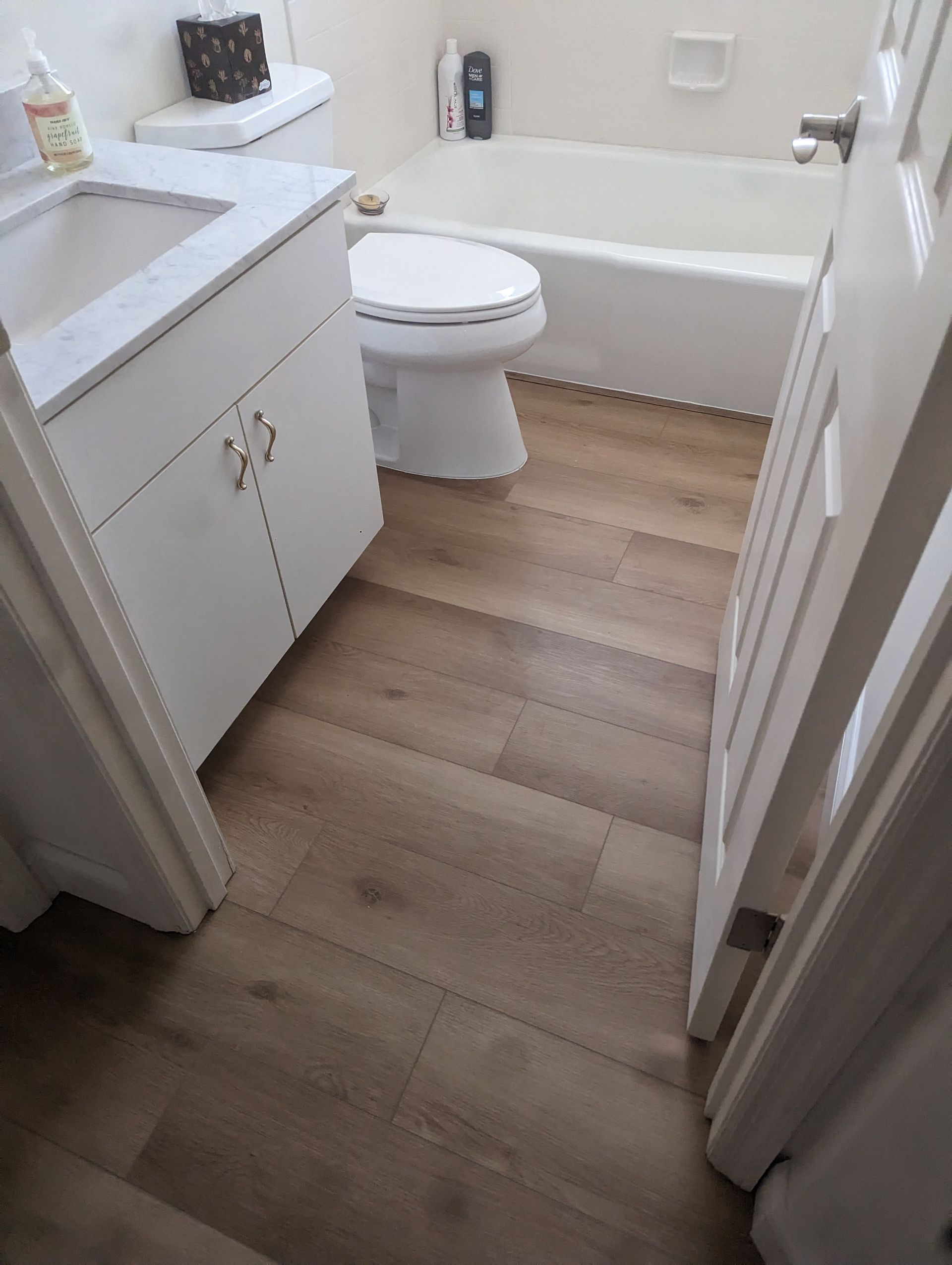 A bathroom with a toilet , sink and bathtub.