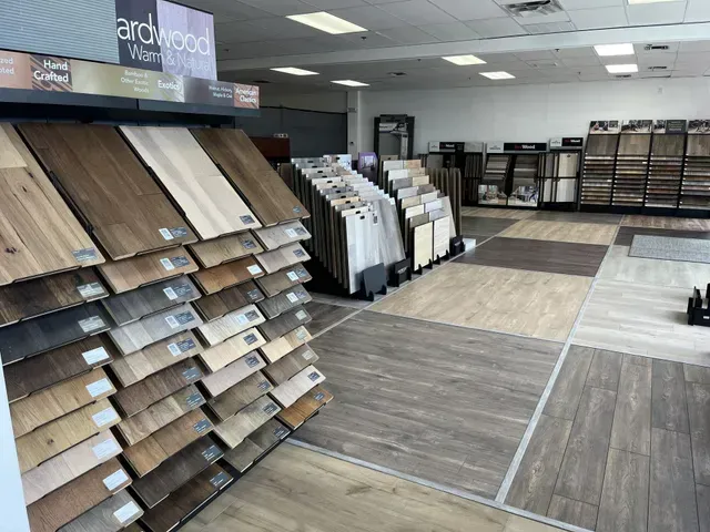 Flooring showroom featuring various hardwood and tile samples on display.