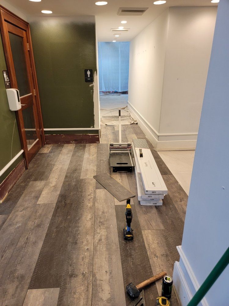 A hallway with a wooden floor and tools on the floor.