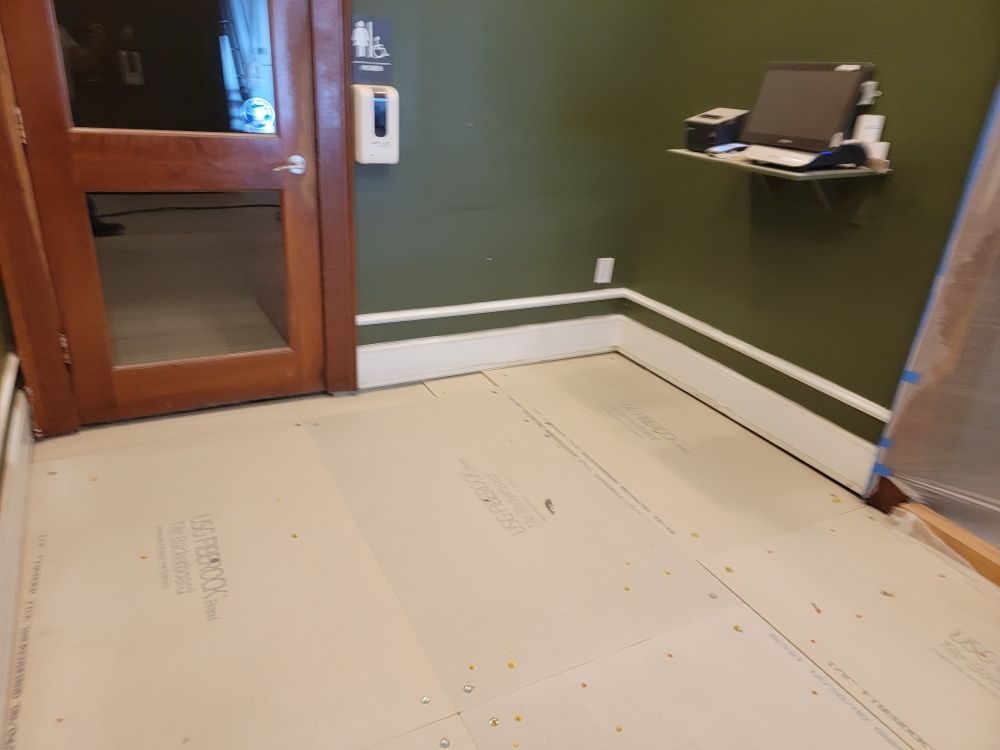 A room with a door and a shelf with a computer on it