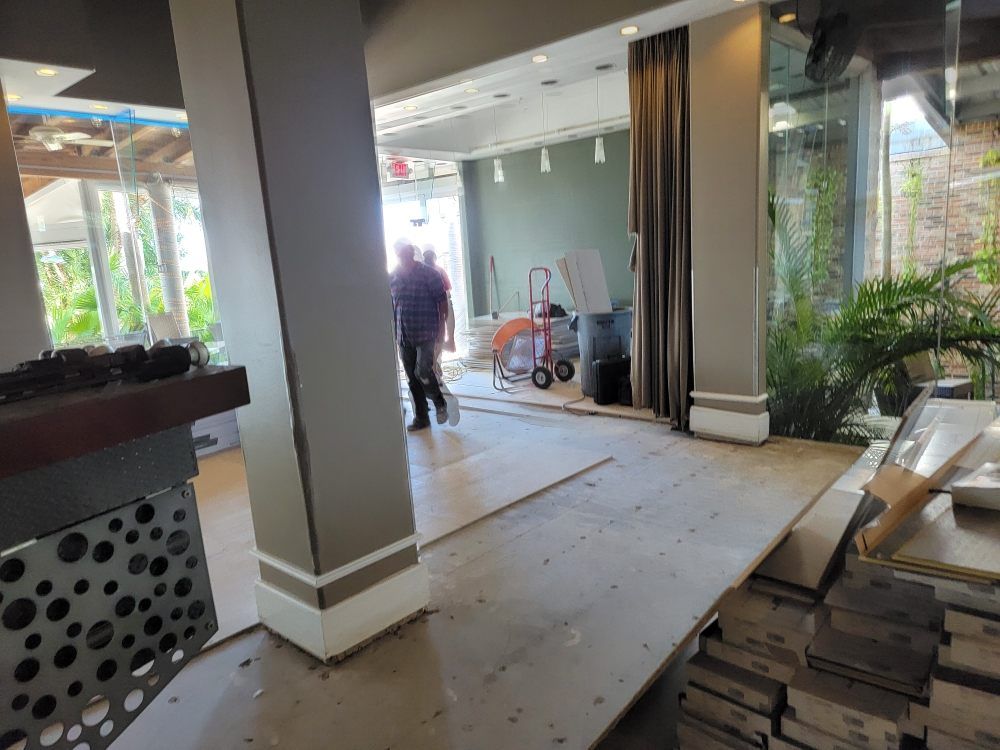 A man is standing in a room with a stack of boxes on the floor.