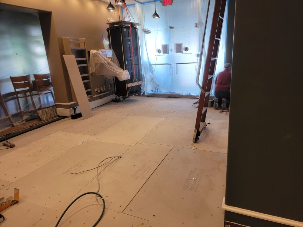 An empty room with a ladder in the middle of it.