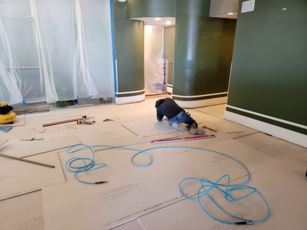 A man is crawling on the floor in a room.