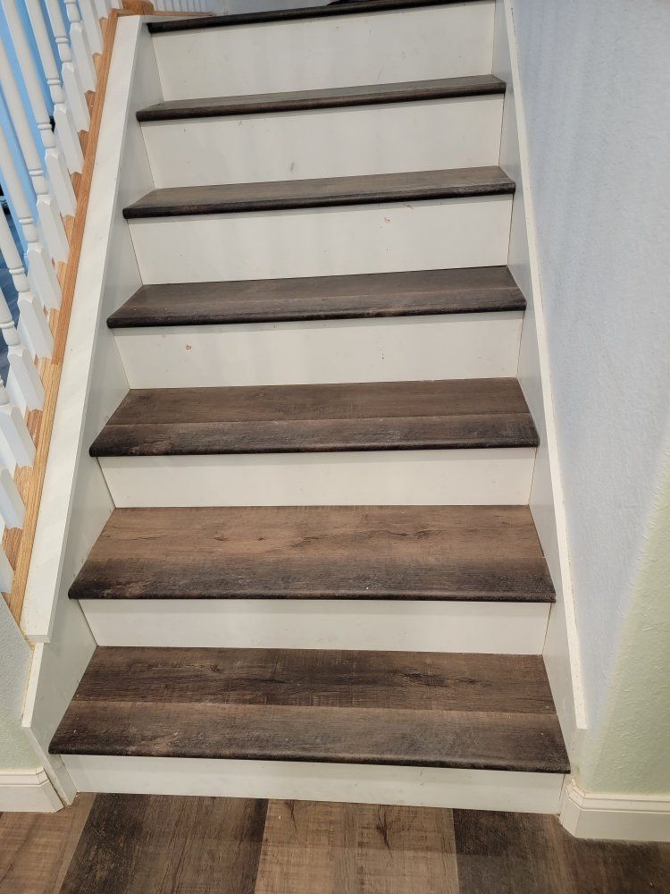 A set of stairs with wooden steps and a white railing.