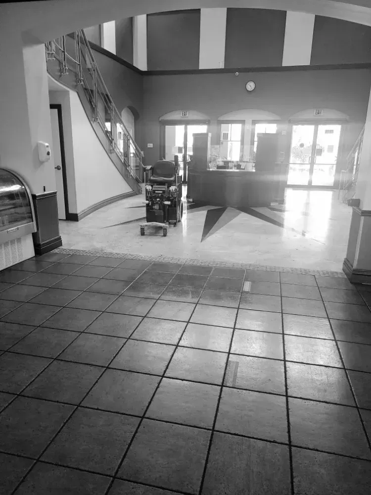 Interior lobby with stairs, front desk, and tiled floor. A wheelchair is in the center.