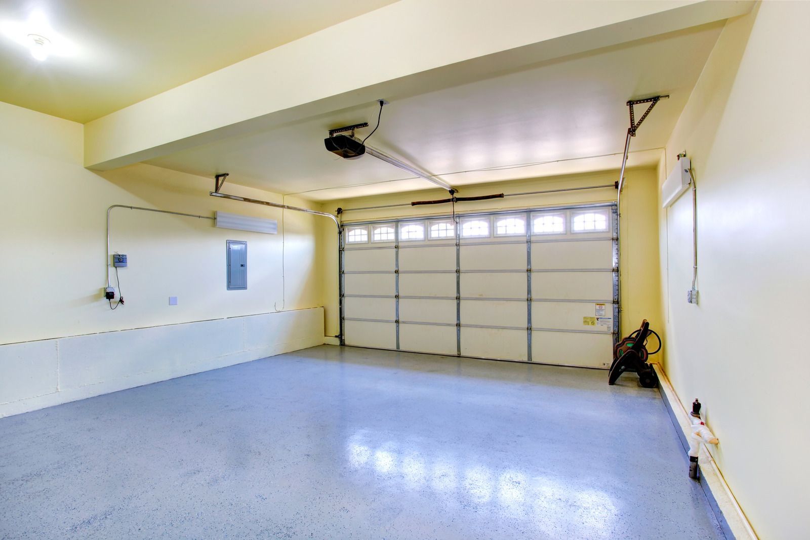 A large empty garage with a garage door open.