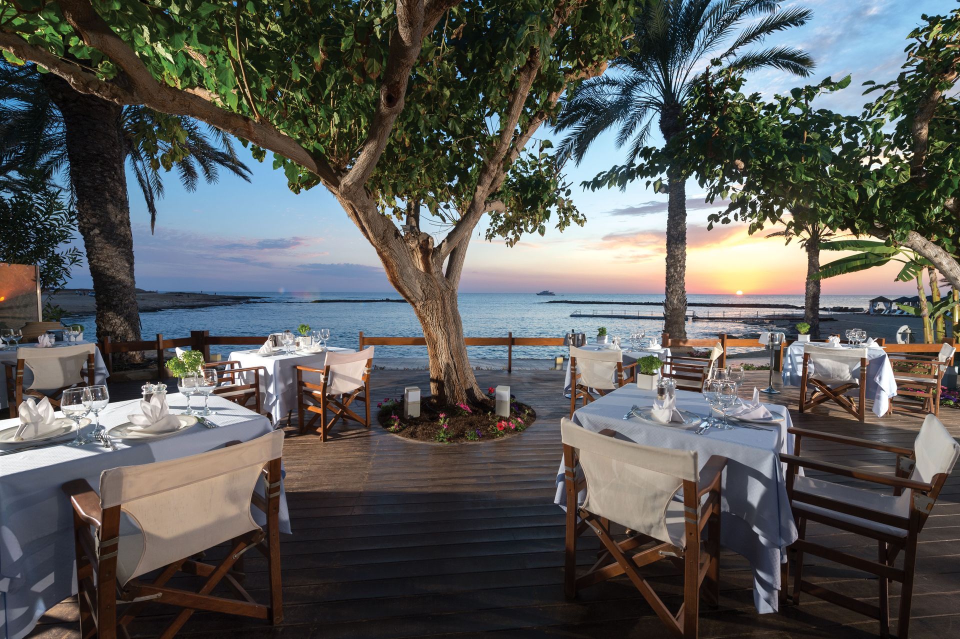 Asimina Suites Hotel A restaurant with tables and chairs overlooking the ocean