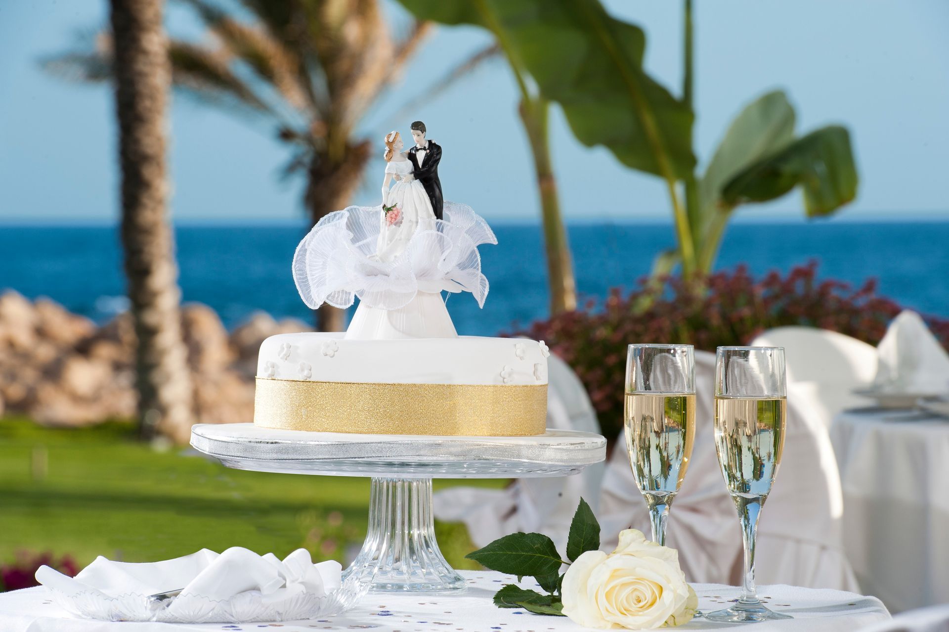 A wedding cake with a bride and groom figurine on top