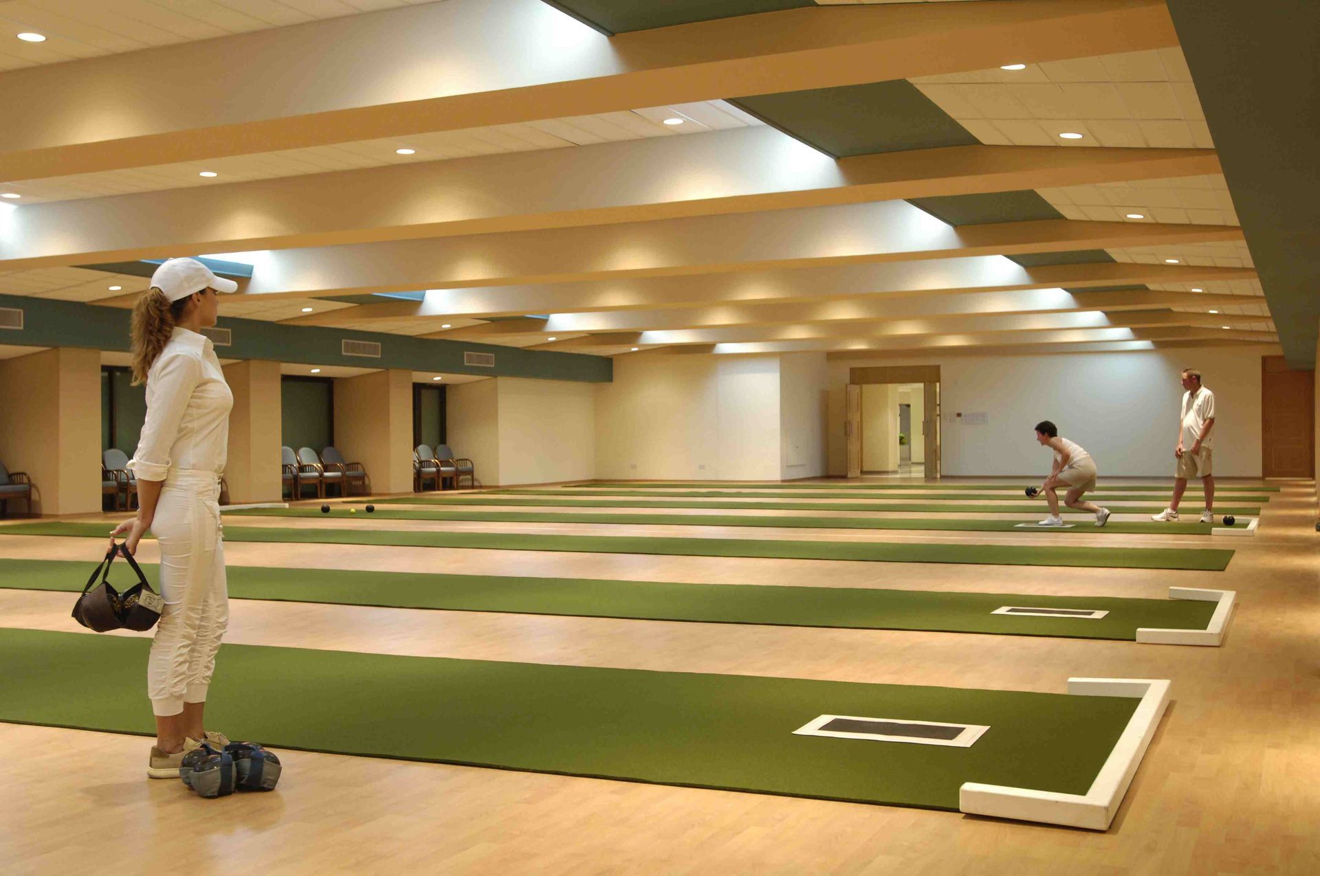 Bowls Holidays A woman is standing in a bowling alley holding a bowling ball