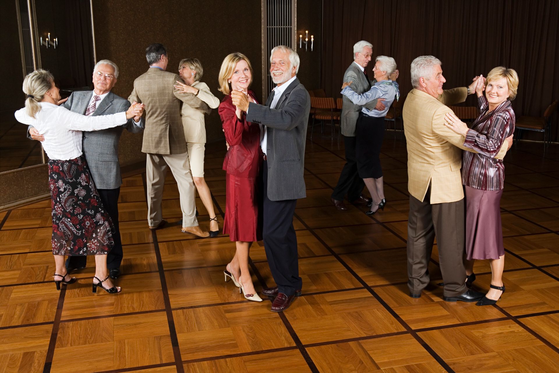 Dance Holidays A group of older people are dancing on a wooden floor.