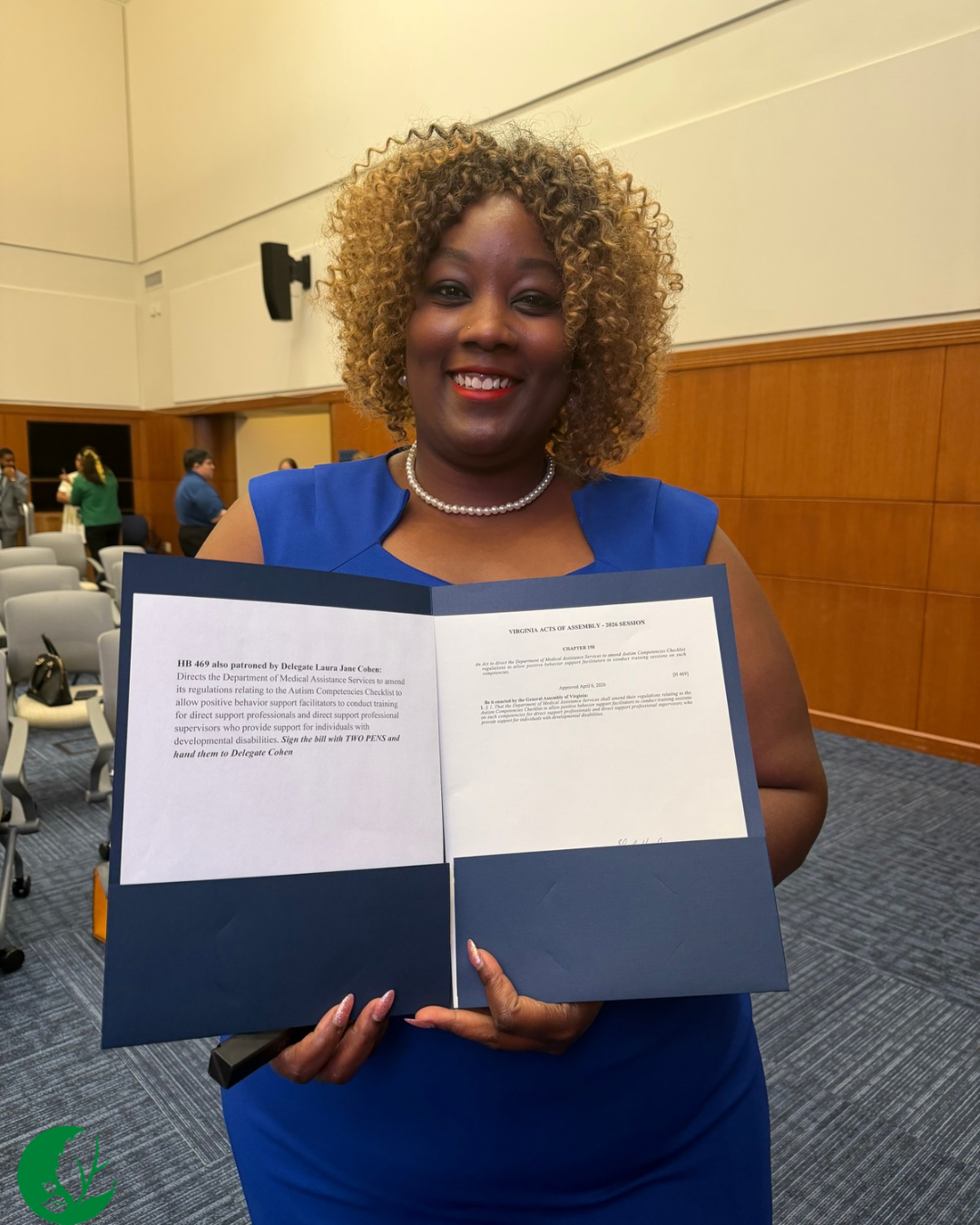 Whitney King holds a copy of bill HB469 and one of the pens Governor Spanberger used to sign the bill.