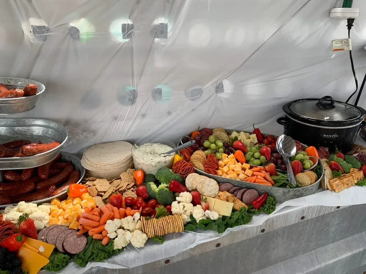 Buffet table of fruit, vegetables, breads, and dips in a catering setup