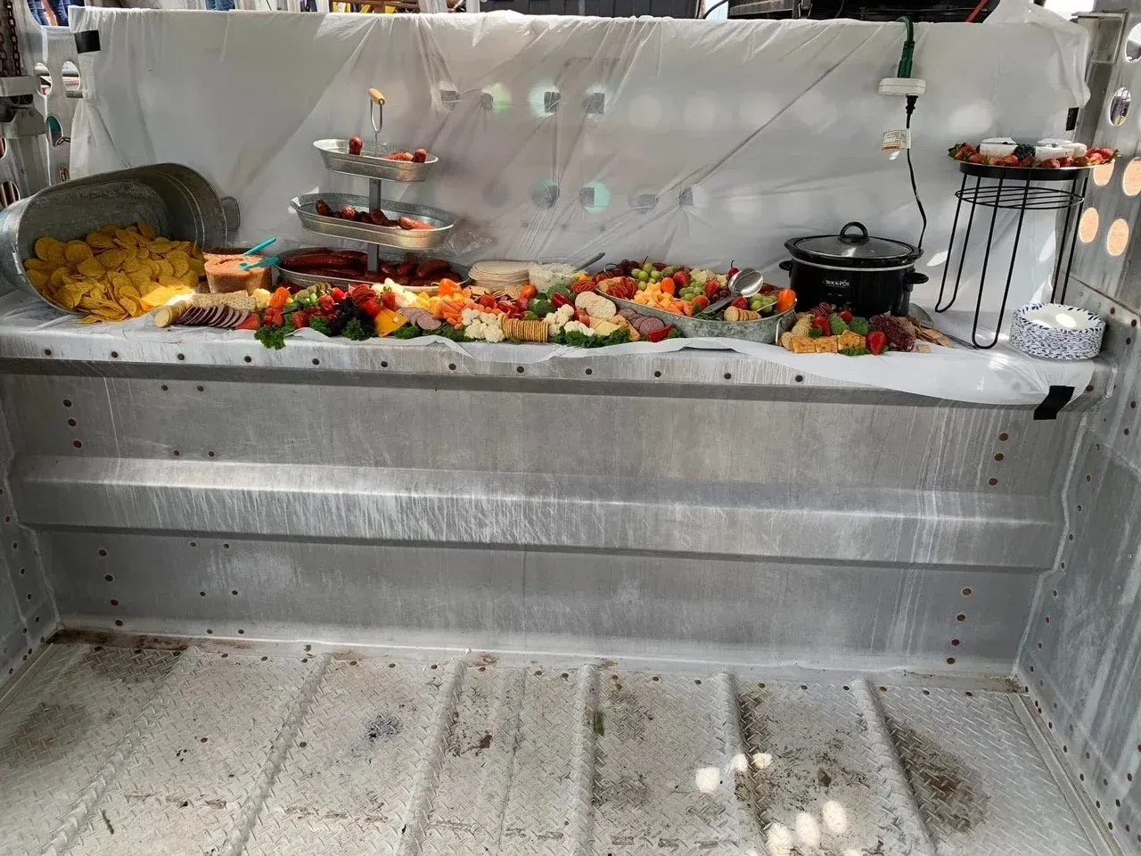 Empty silver buffet tray with flower garlands and candles, decorated for a ceremony