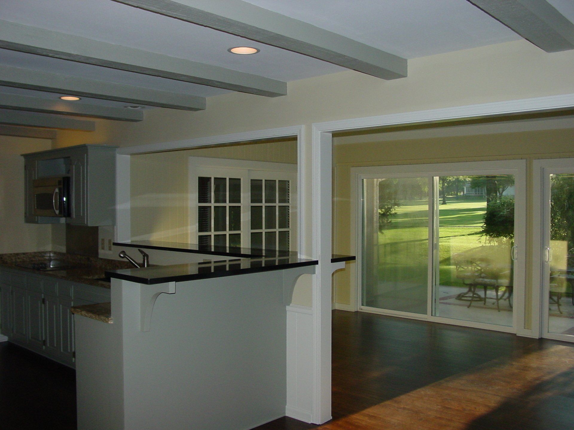 Kitchen with granite countertops and open layout to a patio with sliding glass doors.
