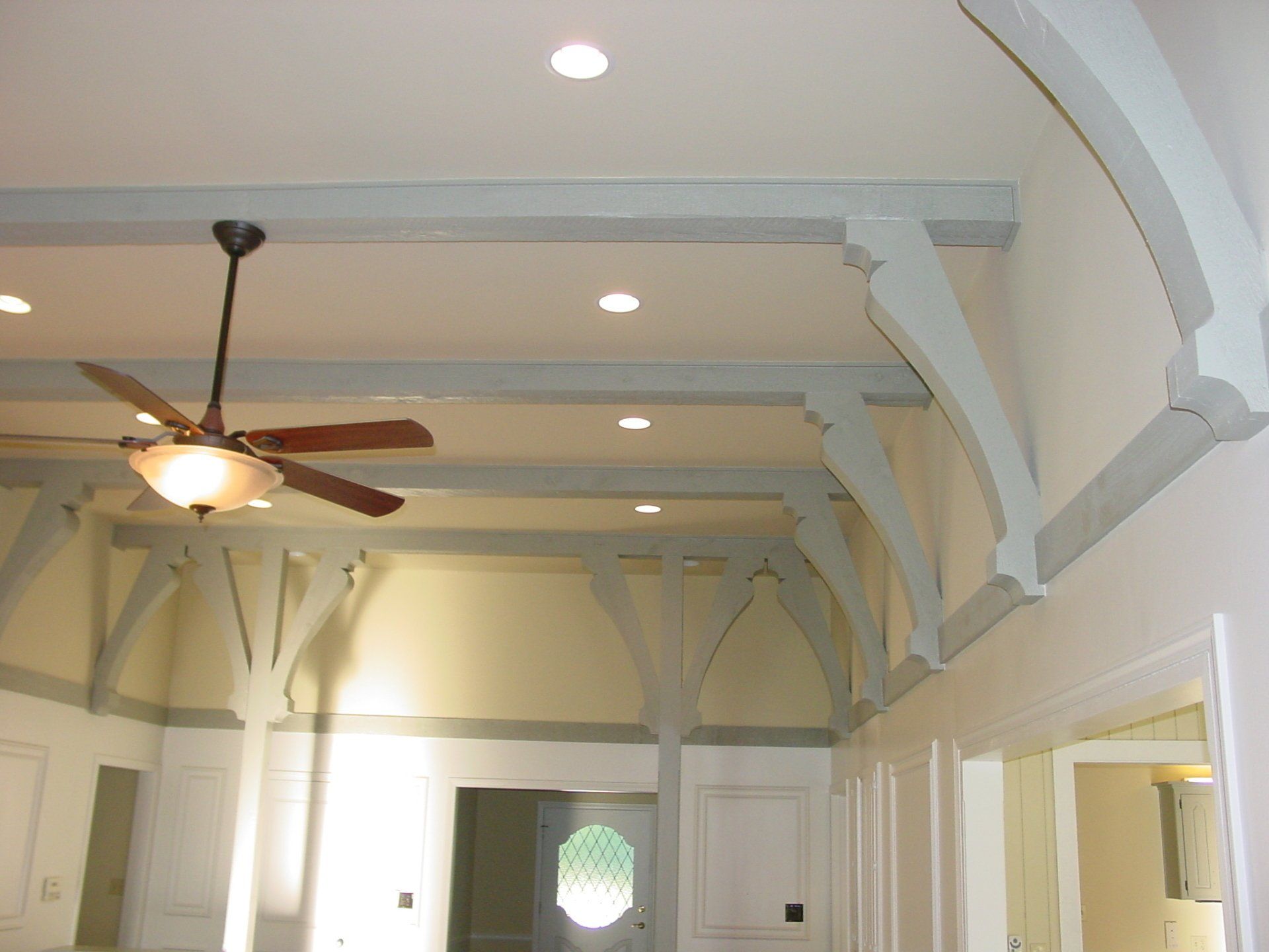 Interior with light blue ceiling beams, ceiling fan, recessed lighting, and white walls.