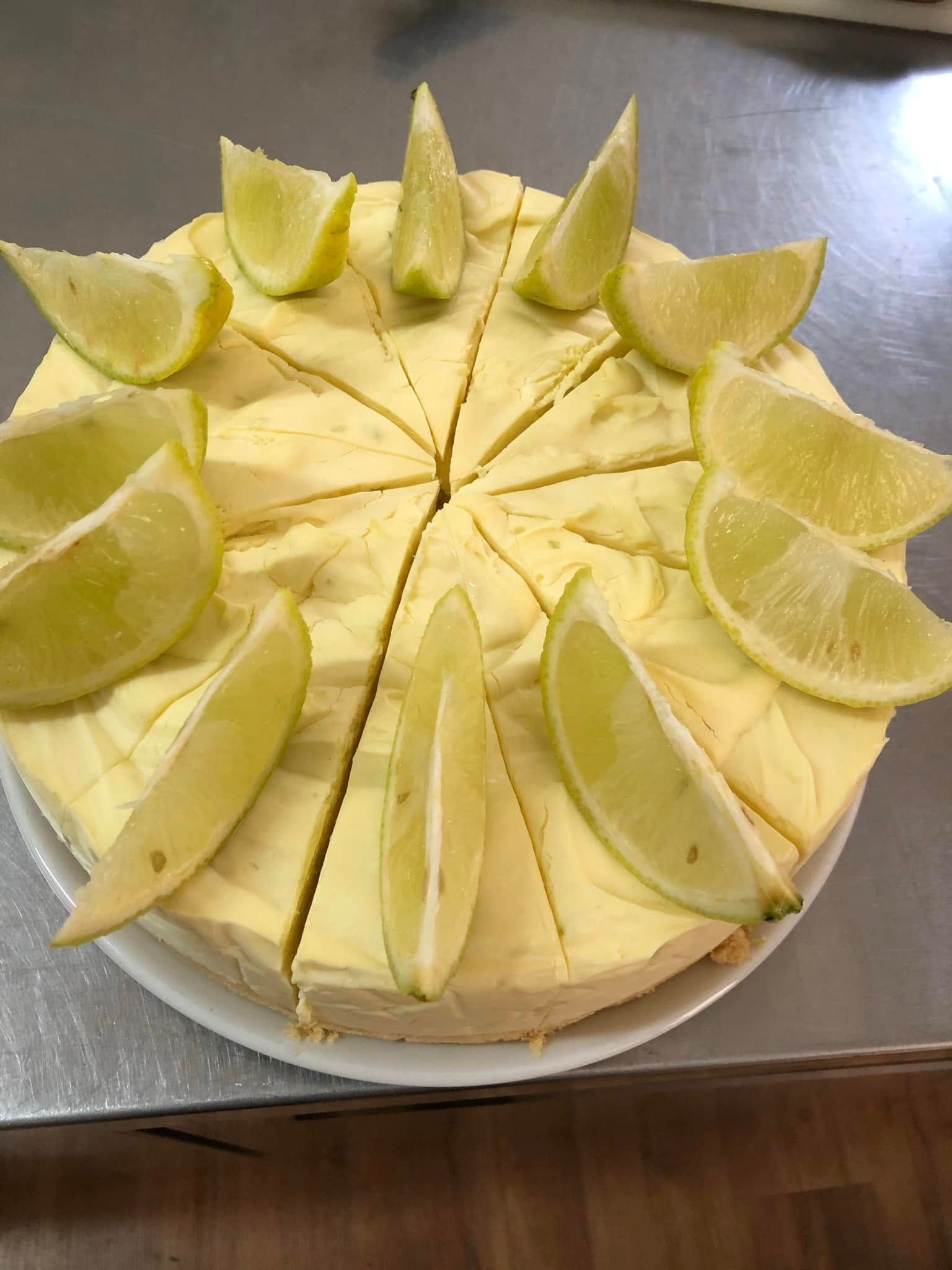Yellow Cheesecake Cut Into Slices, Garnished with Lime Wedges — Kape Centro In Childers, QLD 