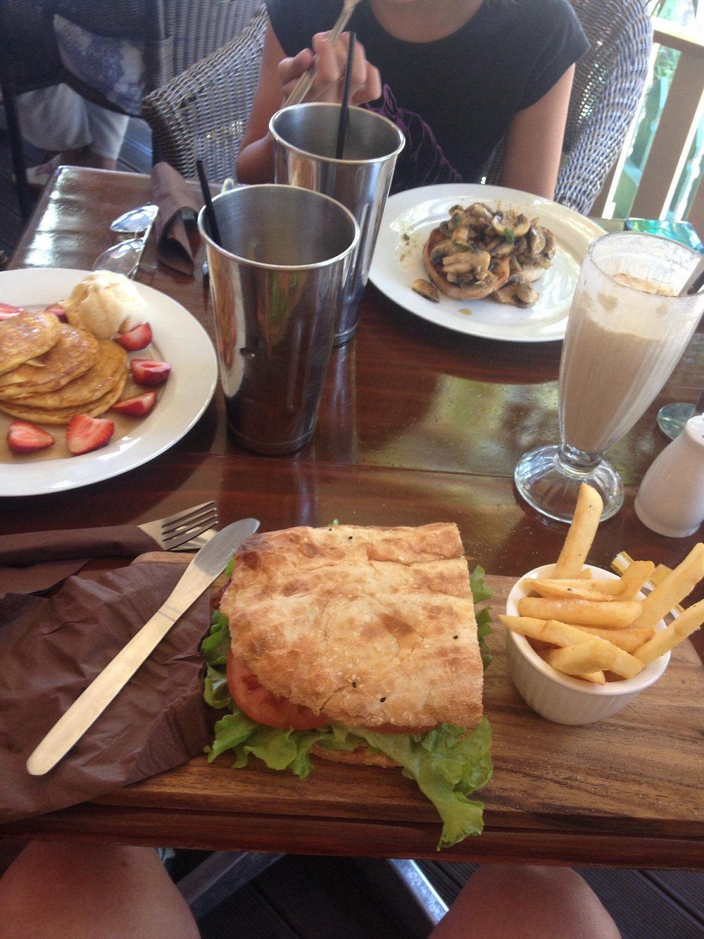 Brunch Table with Pancakes, Sandwich, Fries, Mushrooms, Smoothies, and Two People — Kape Centro In Childers, QLD