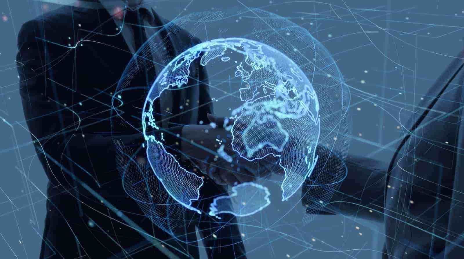 Two business professionals in suits shaking hands, overlaid with a digital blue globe