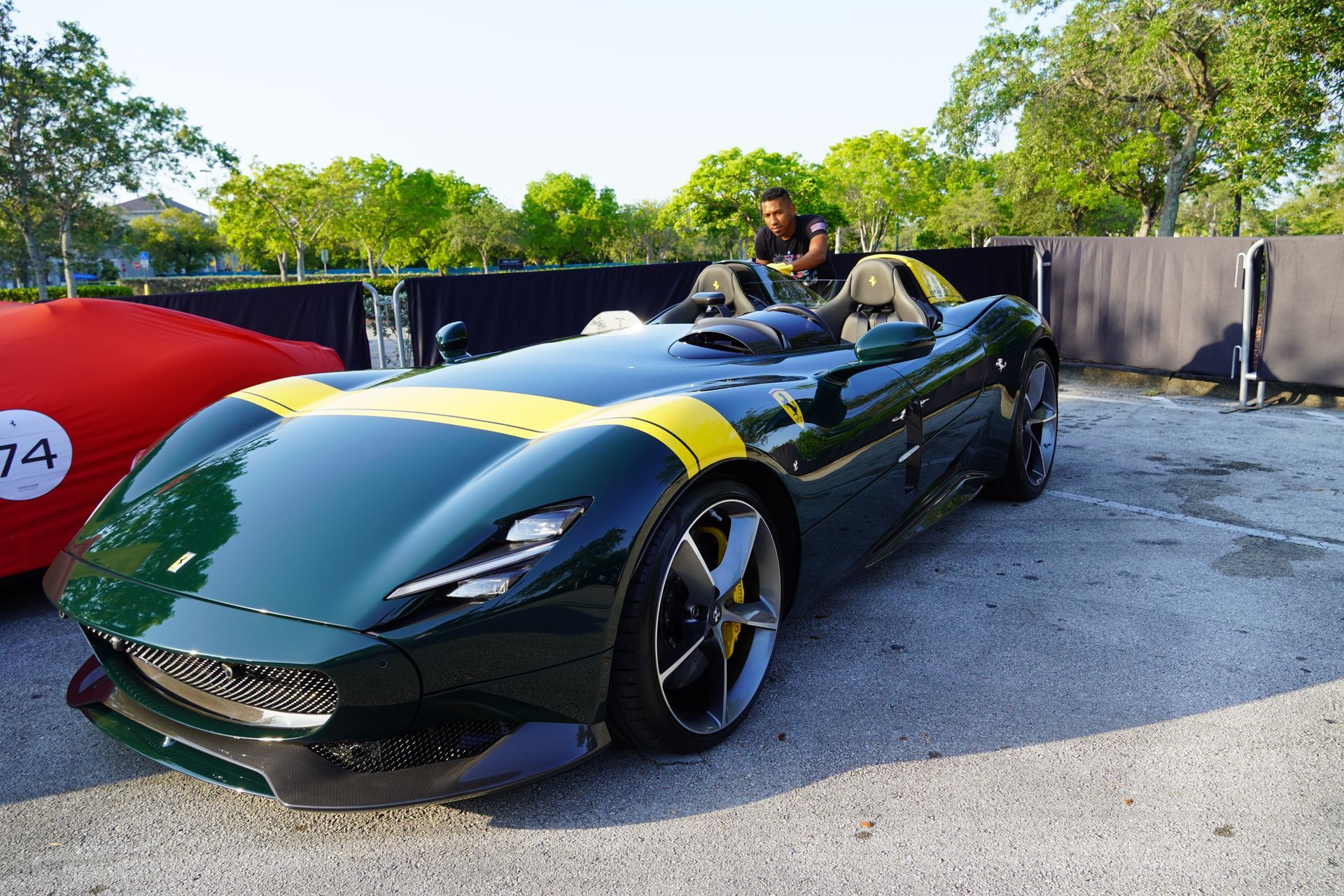 A green sports car with yellow stripes is parked in a parking lot