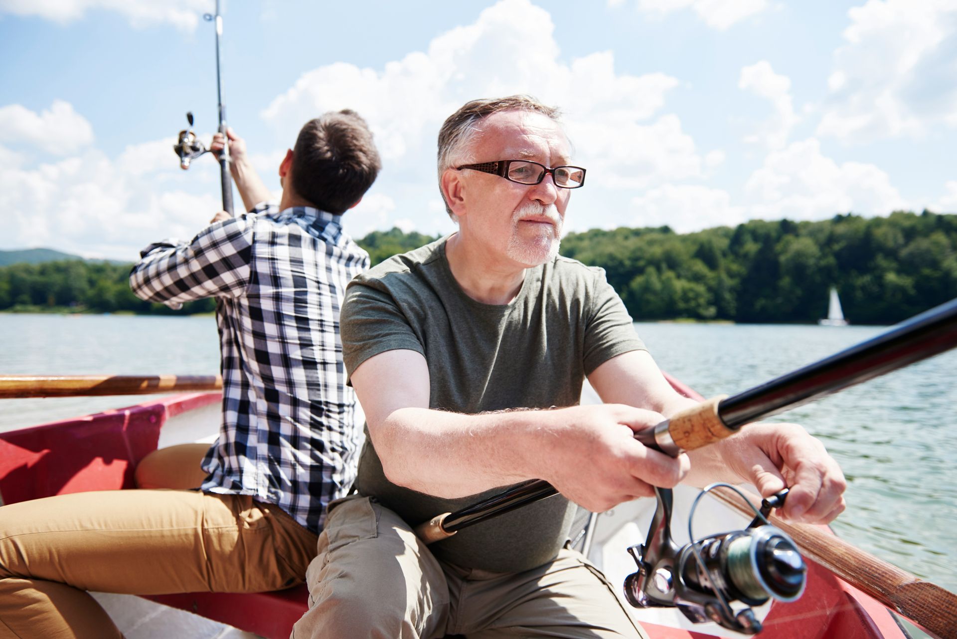 Two men are fishing in a boat on a lake.