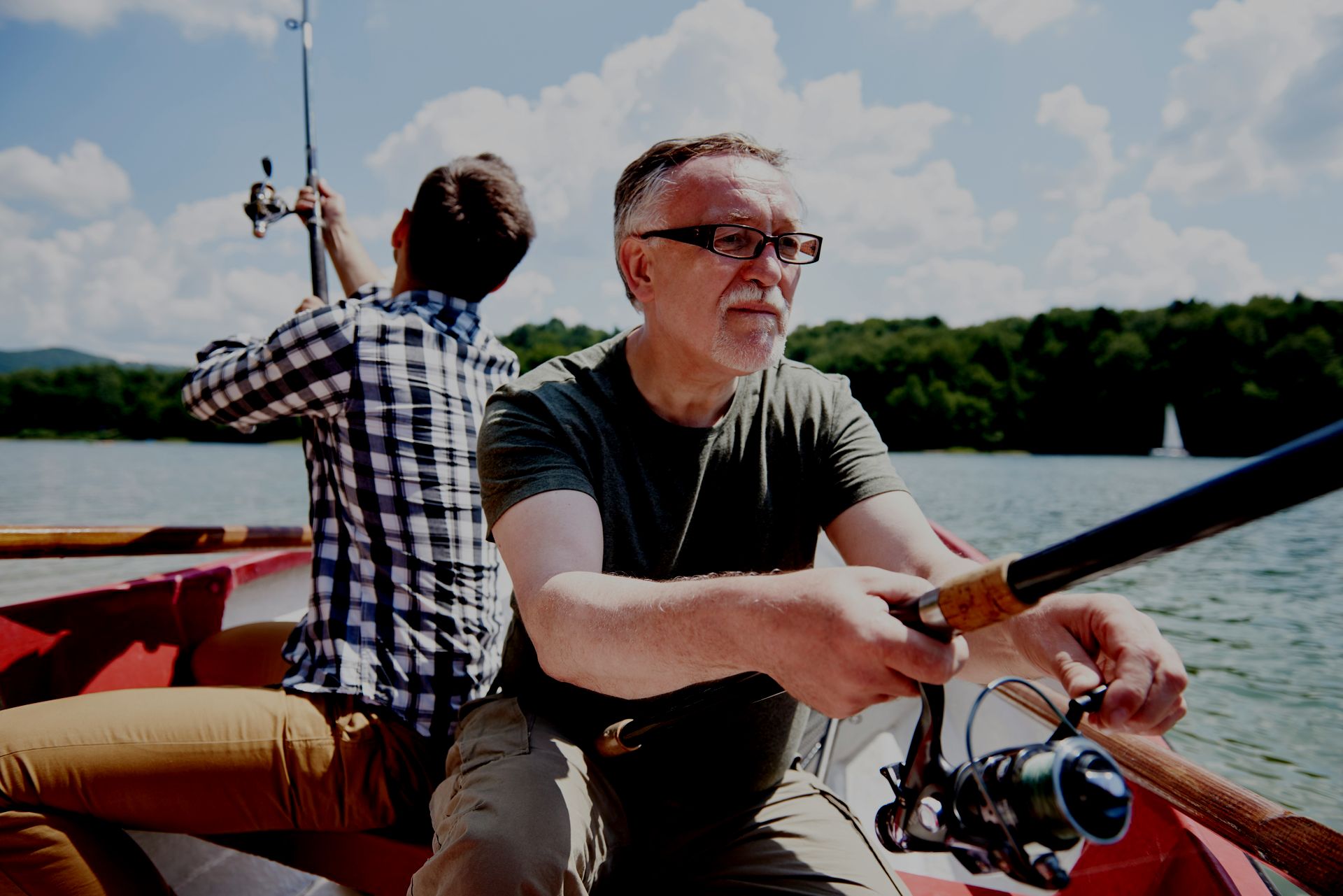 Two men are fishing in a boat on a lake.