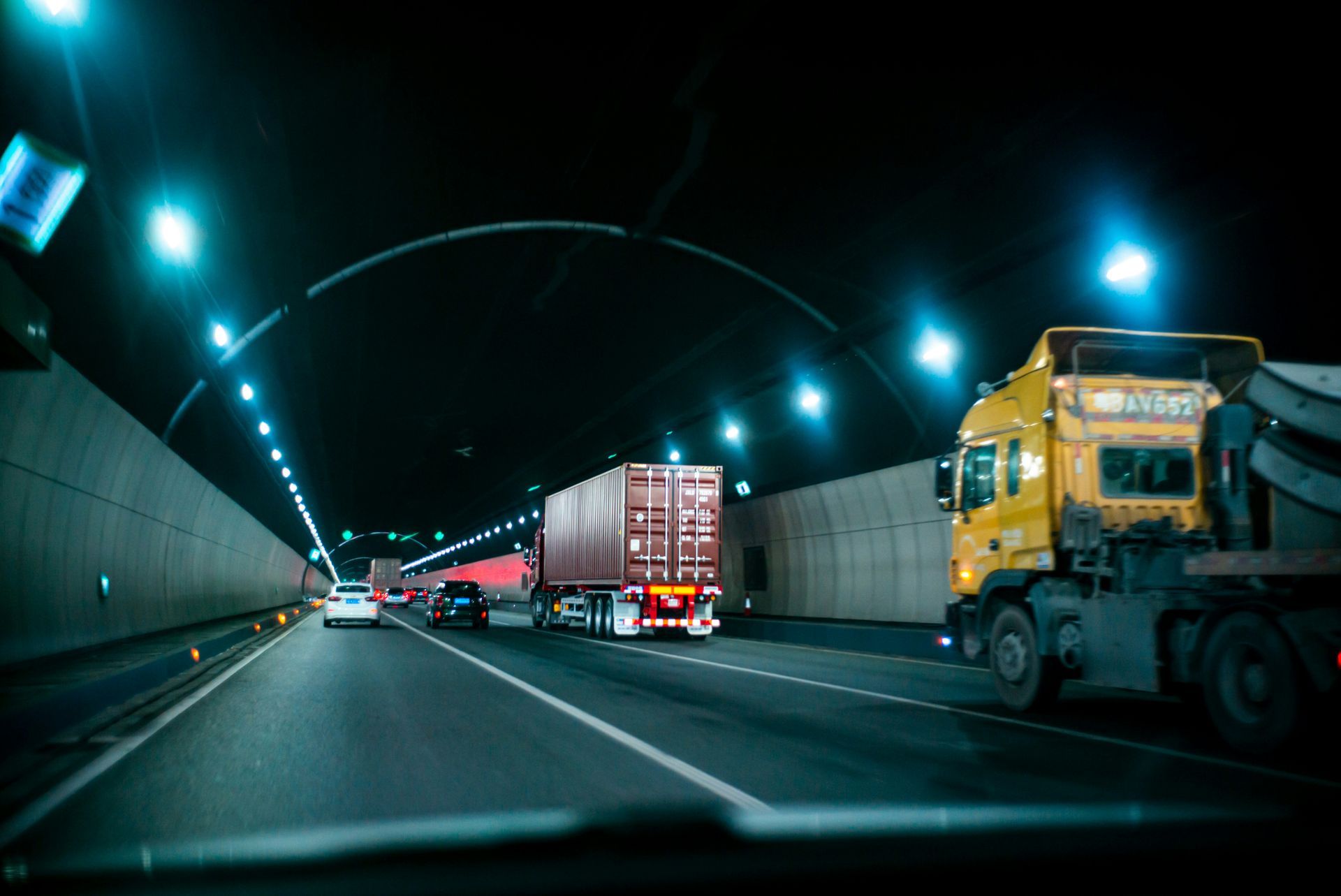 A truck is driving through a tunnel at night.