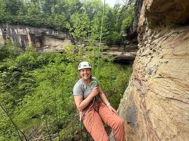 First-time climber in athletic clothing and harness after climbing a sandstone route at the Red 