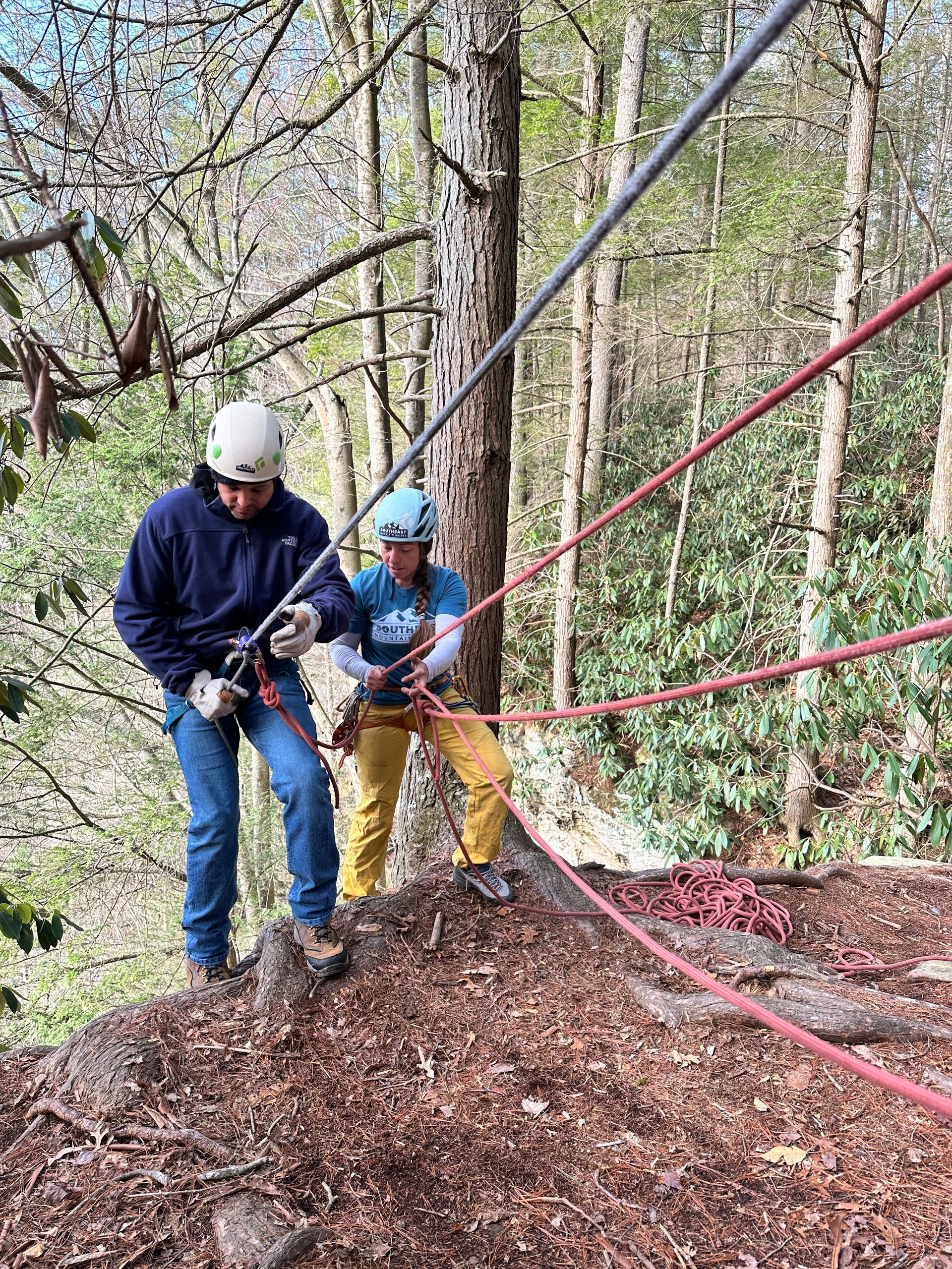 A guide helps a client begin a rappel in the Red River Gorge with Southeast Mountain Guides