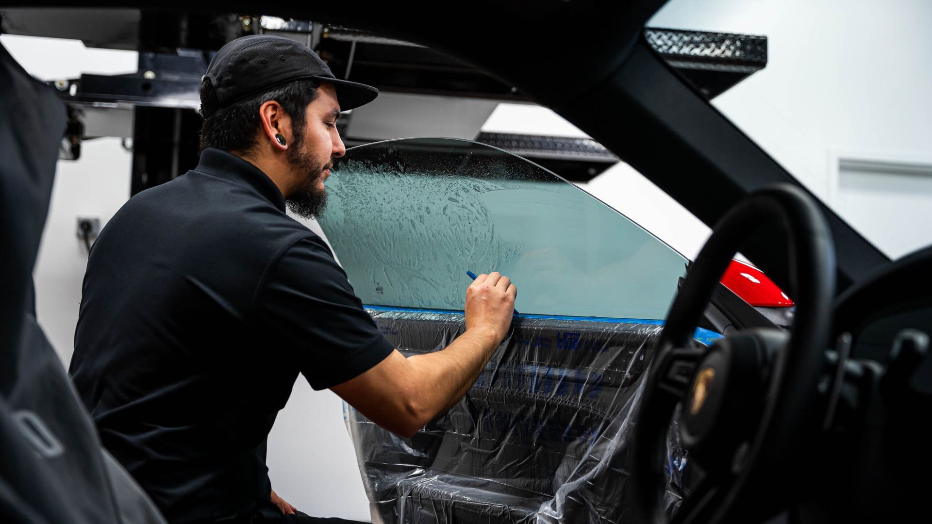 A man is sitting in the driver 's seat of a car.