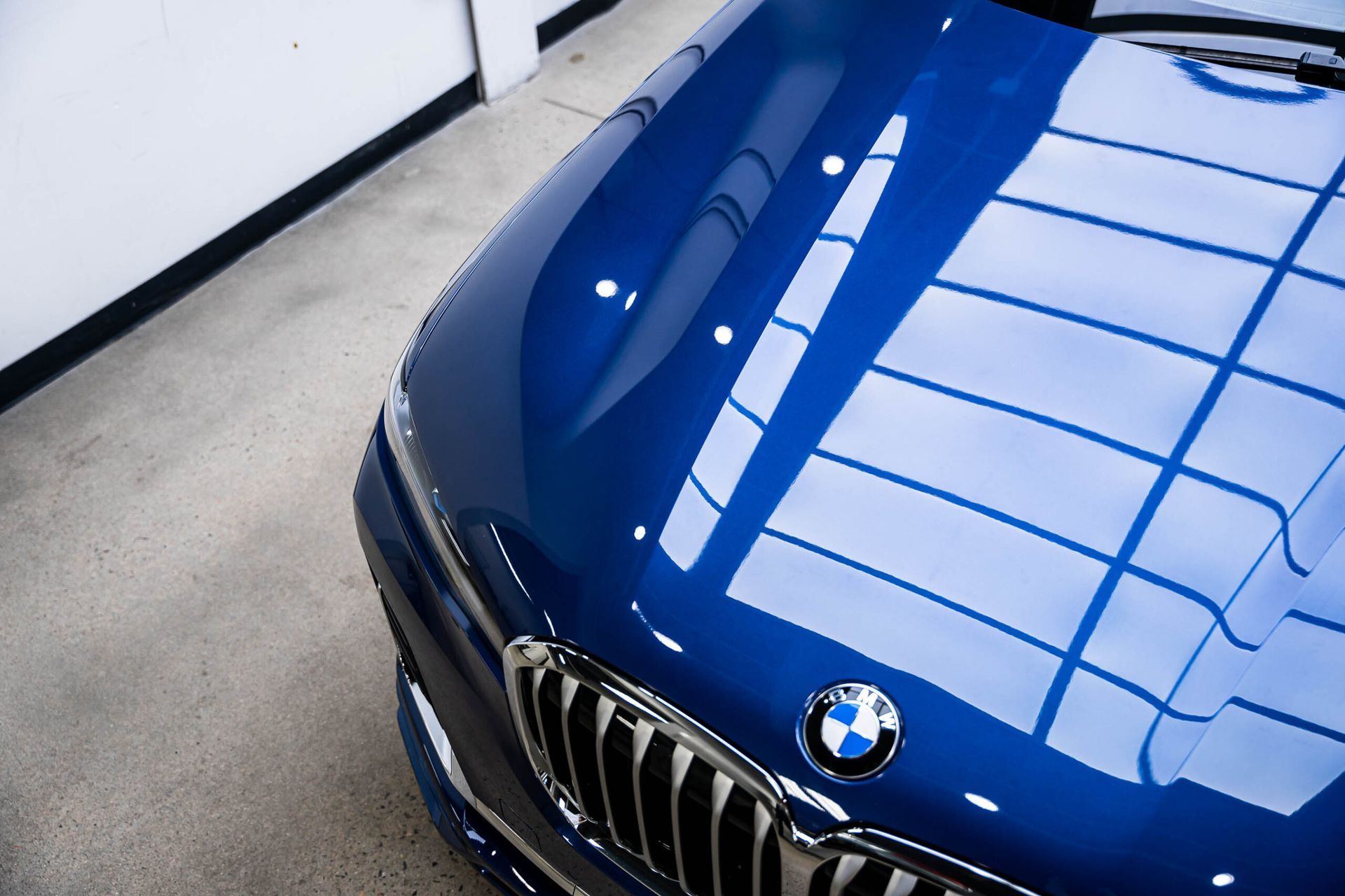 A close up of the hood of a blue bmw