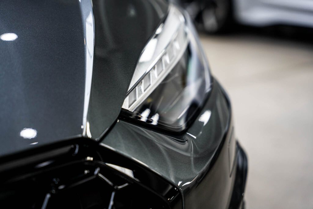 A close up of a car 's headlight in a showroom.