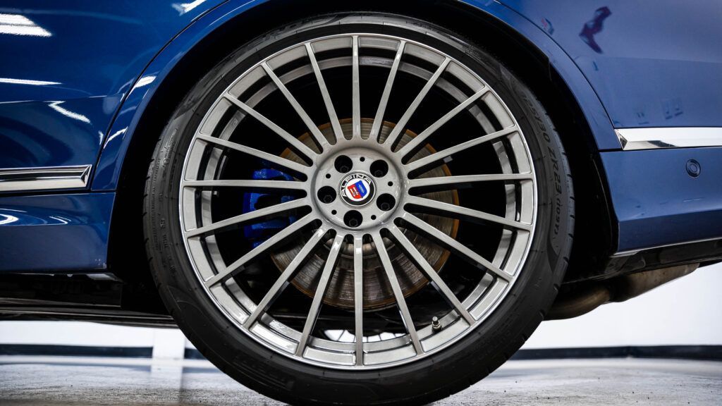 A close up of the wheel of a blue car.