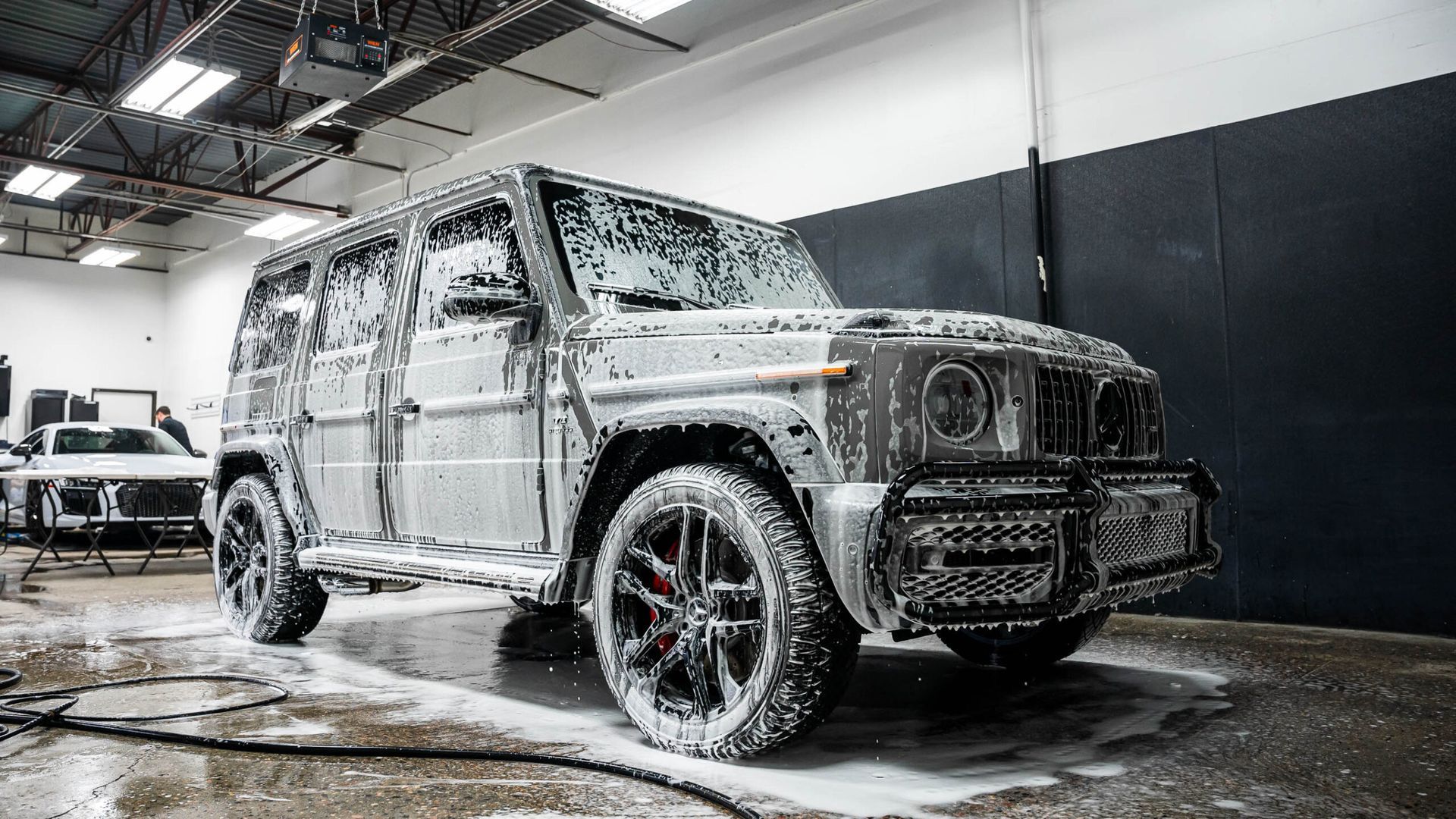 A jeep is covered in foam in a garage.