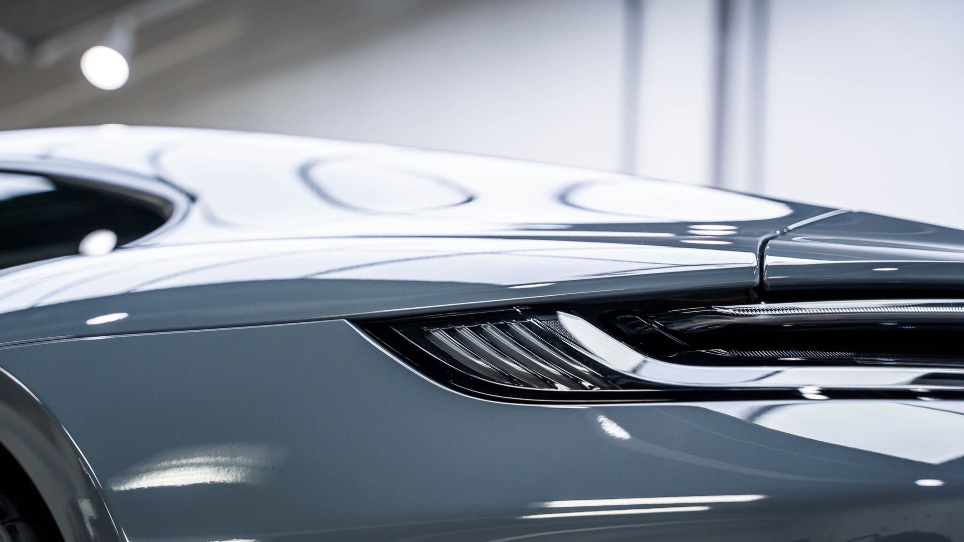 A close up of the rear end of a sports car in a garage.