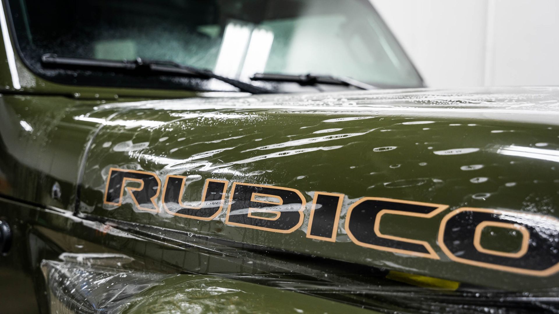 A green jeep with the word rubicon on the hood.