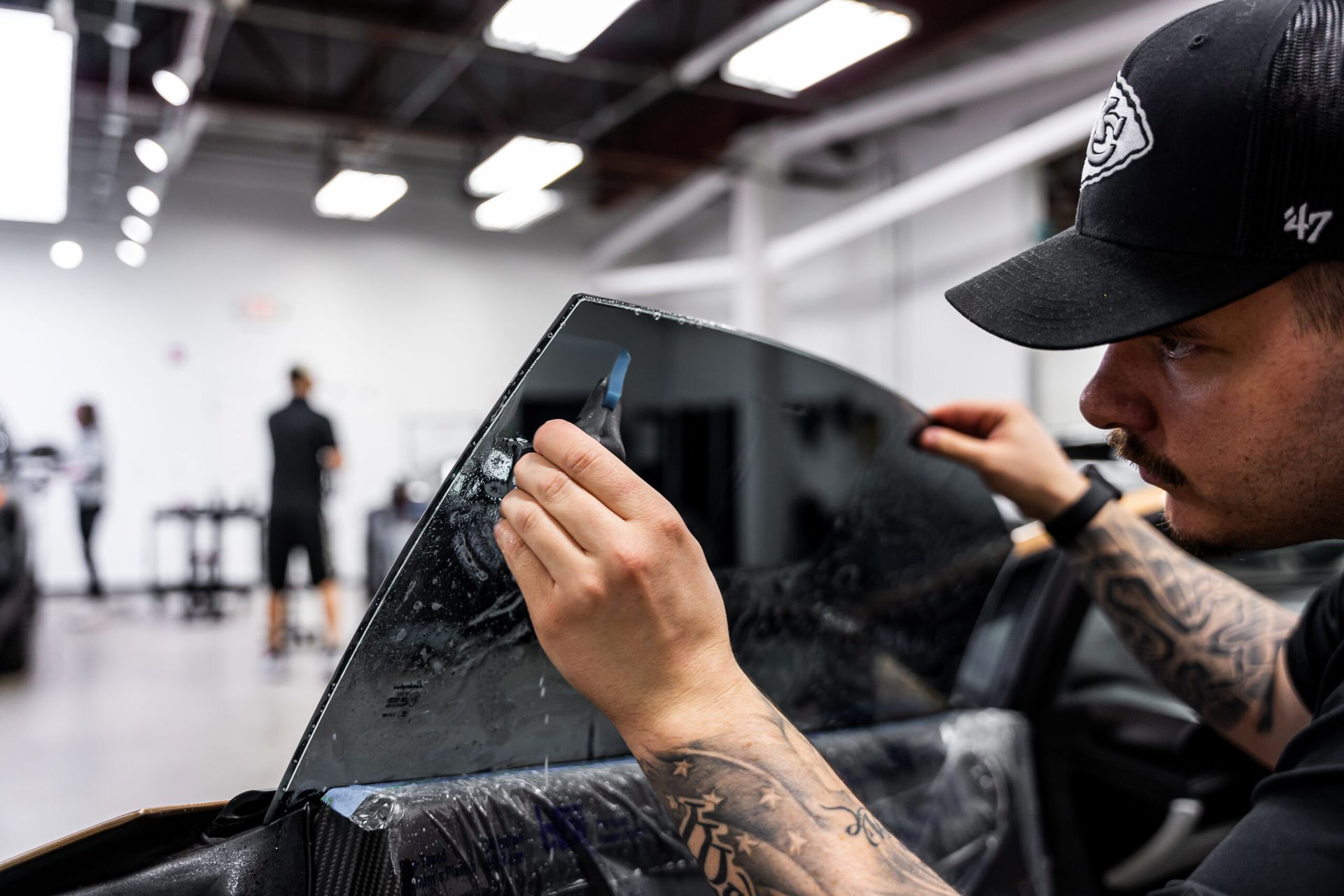 A man is applying window tinting to a car window.