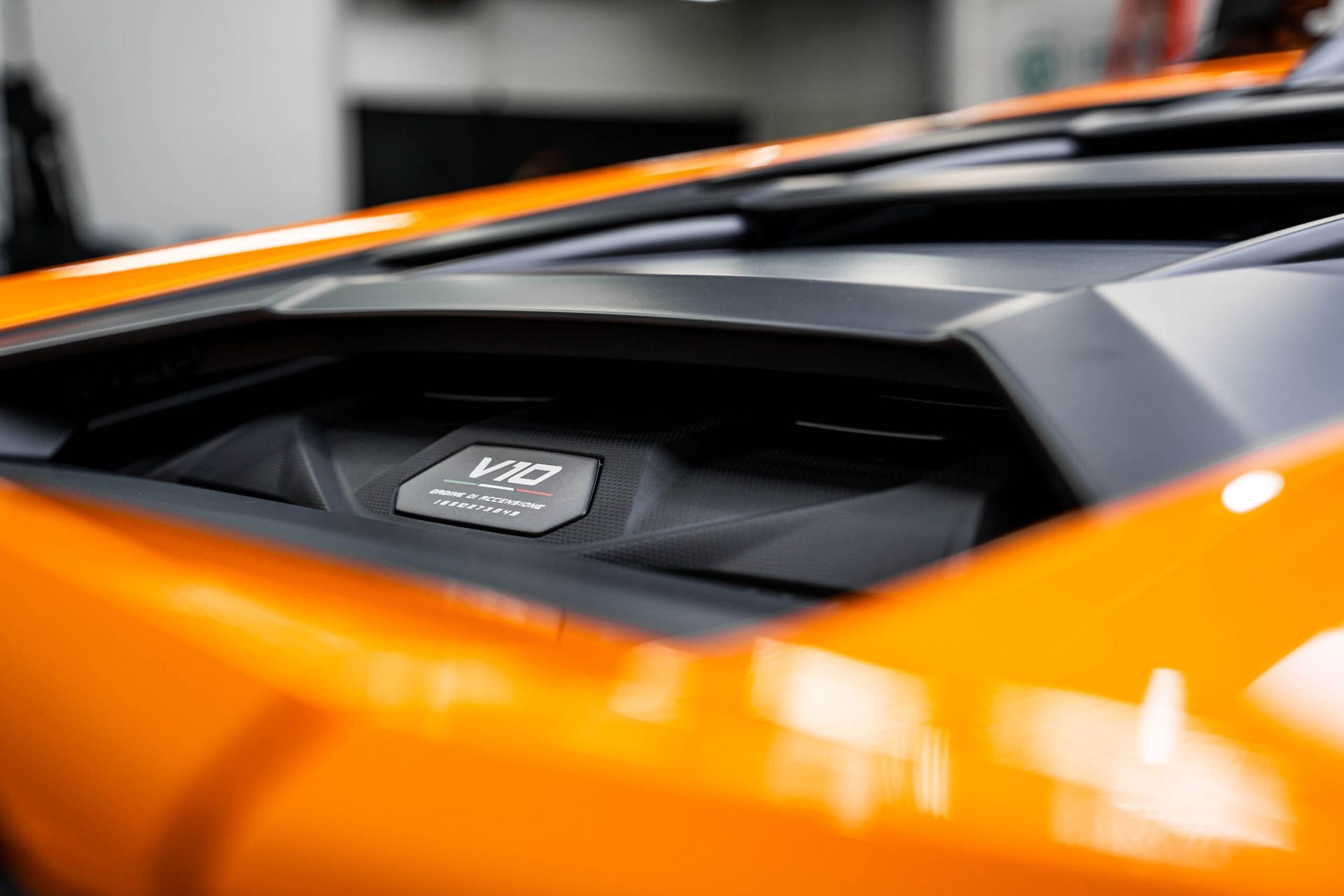 A close up of the engine of an orange sports car.