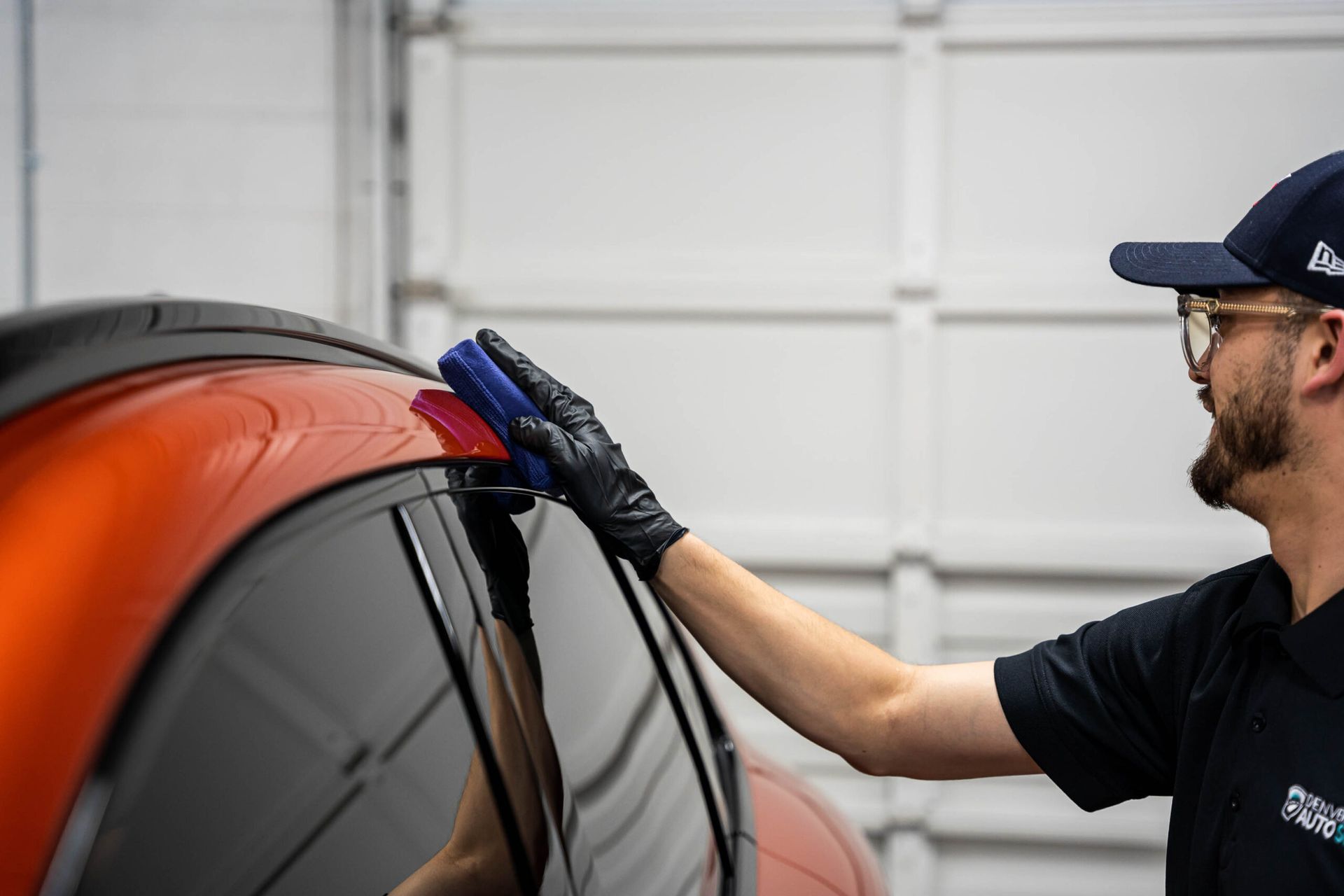 A man is polishing a car with a sponge.