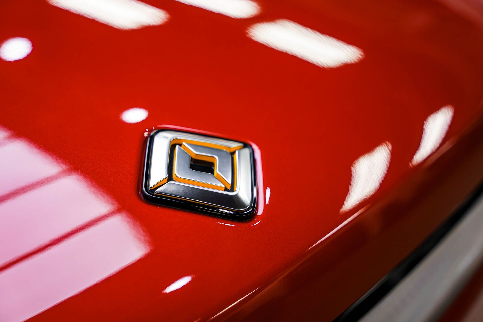 A close up of a red car with a renault logo on the hood