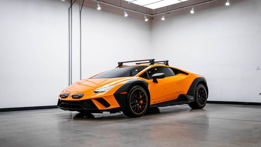 An orange lamborghini huracan is parked in a garage.