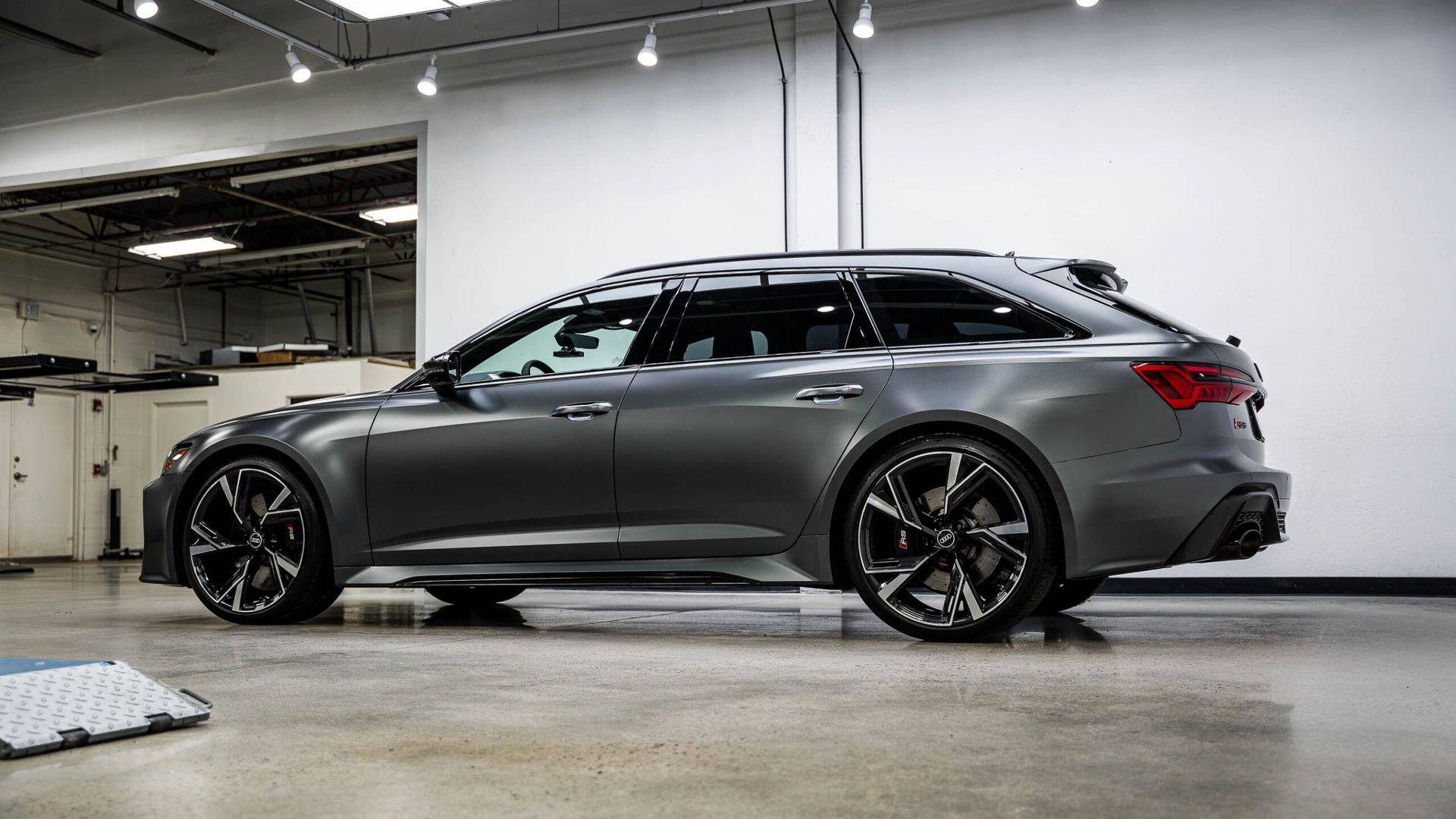 A gray audi rs6 avant is parked in a garage.