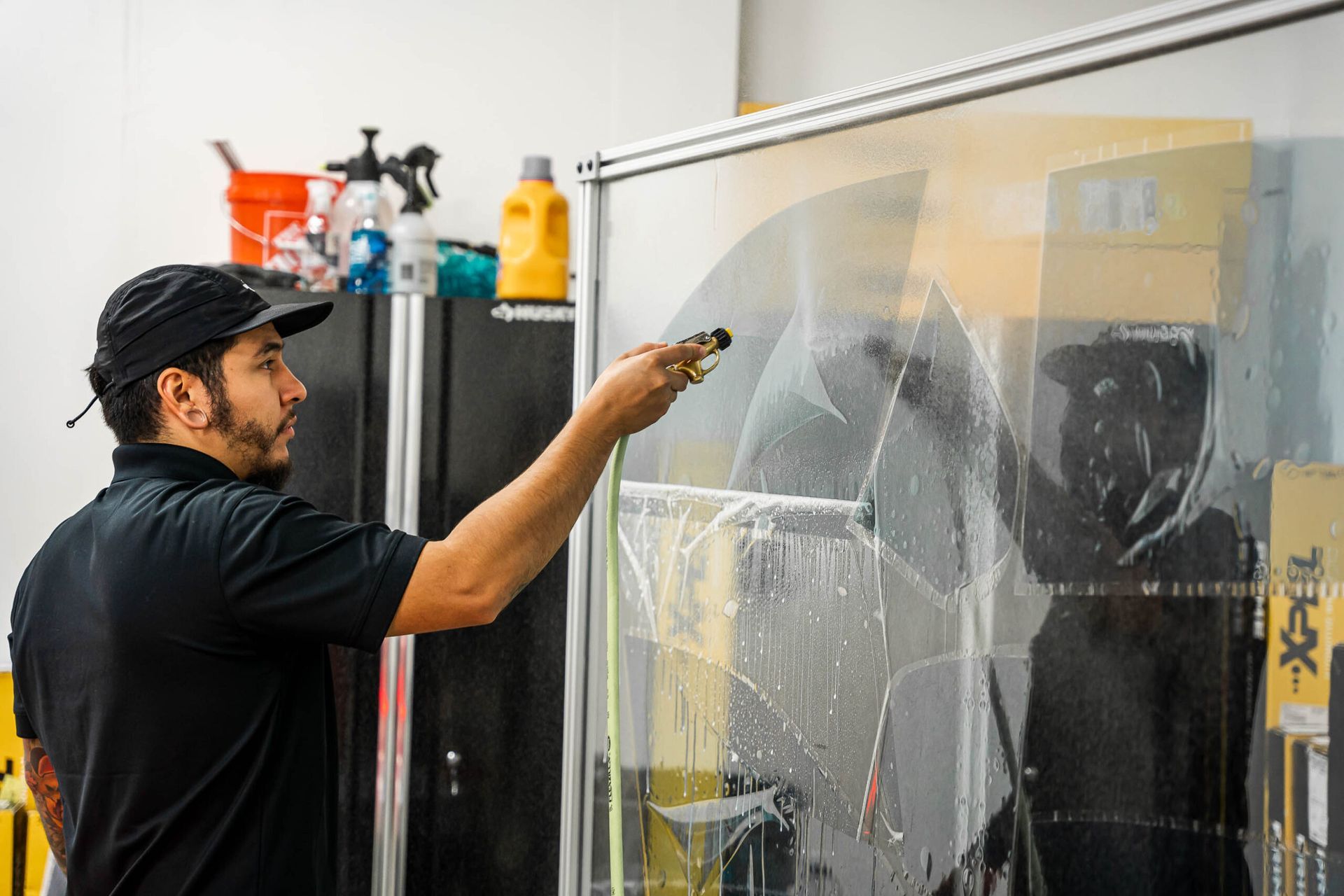 A man is cleaning a window with a spray bottle.