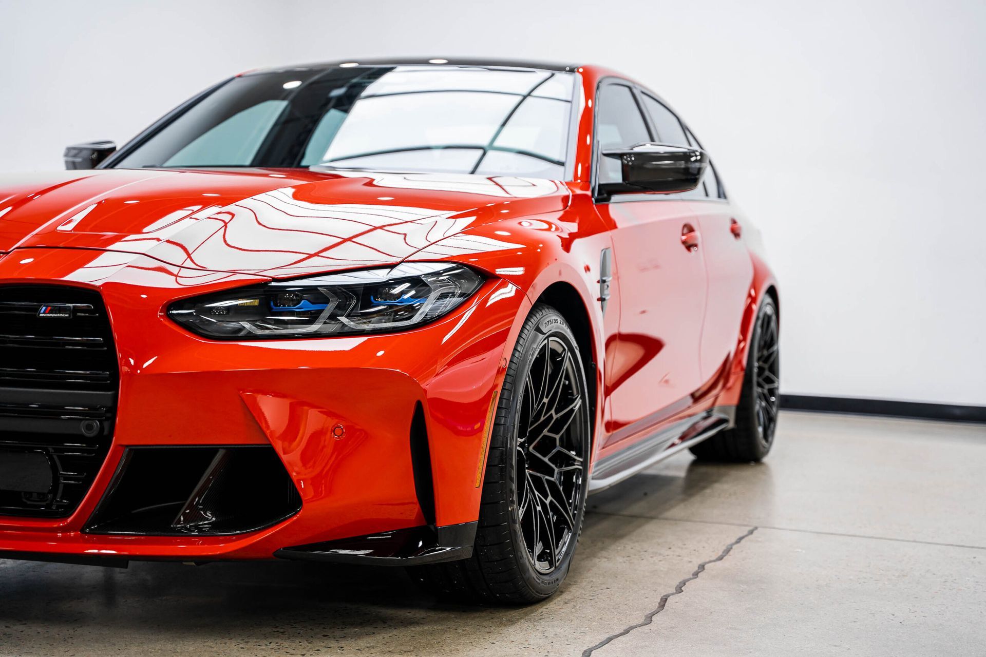 A red bmw m3 is parked in a showroom.