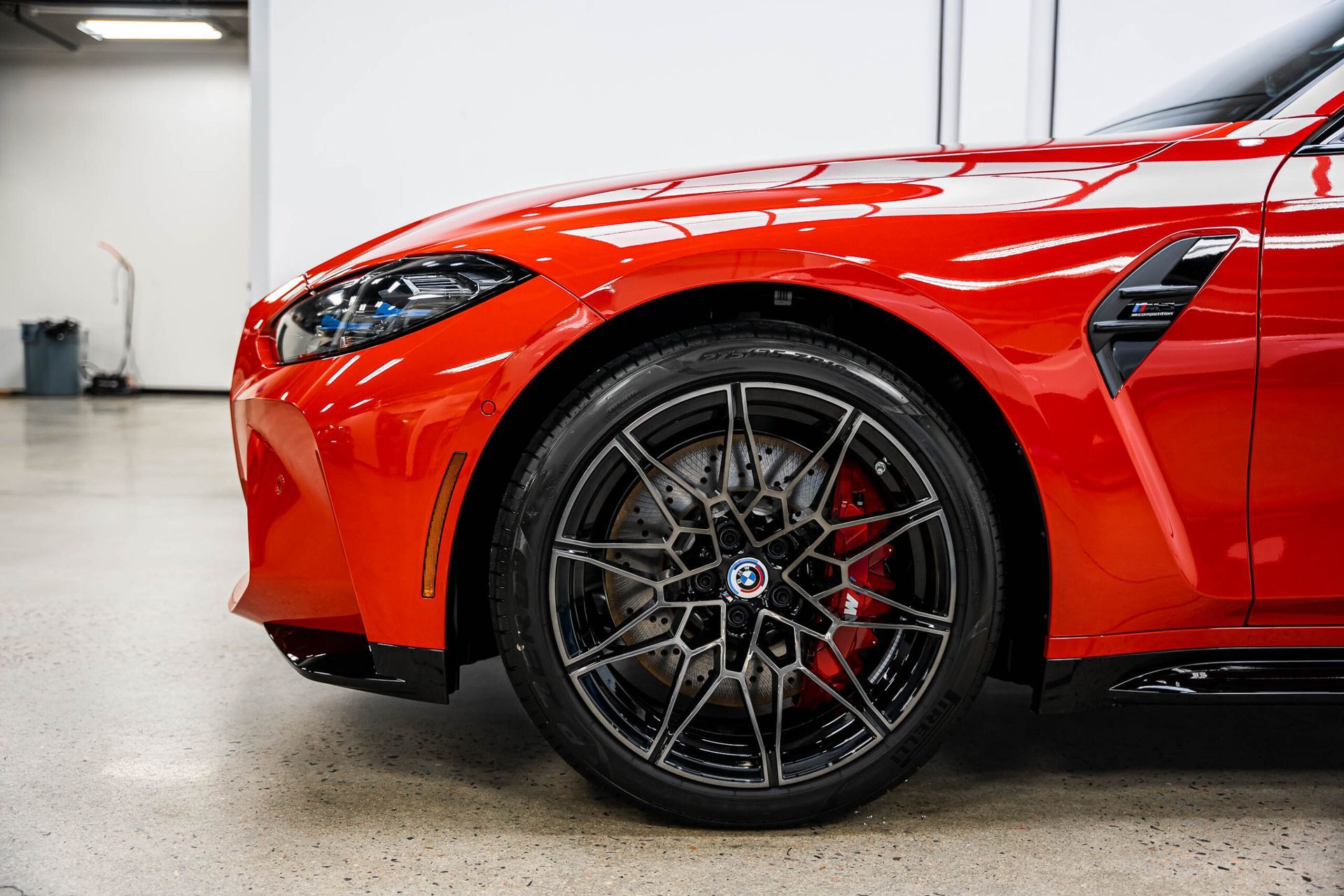 A red bmw m3 is parked in a garage.