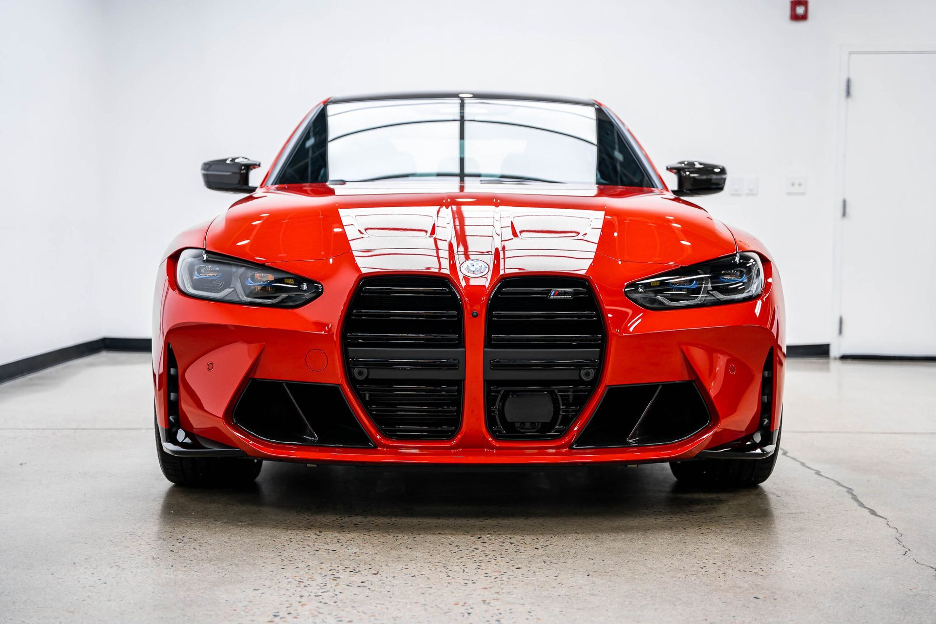 A red bmw m4 is parked in a garage.