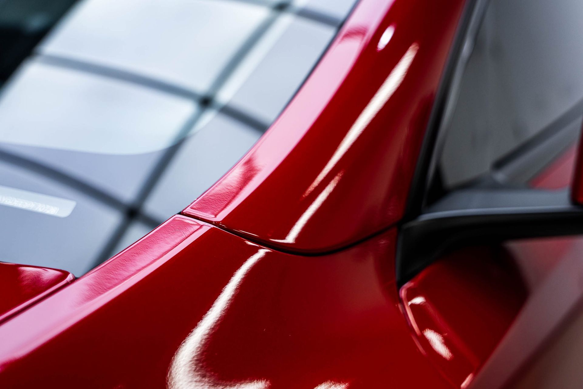 A close up of a red car with a black side mirror