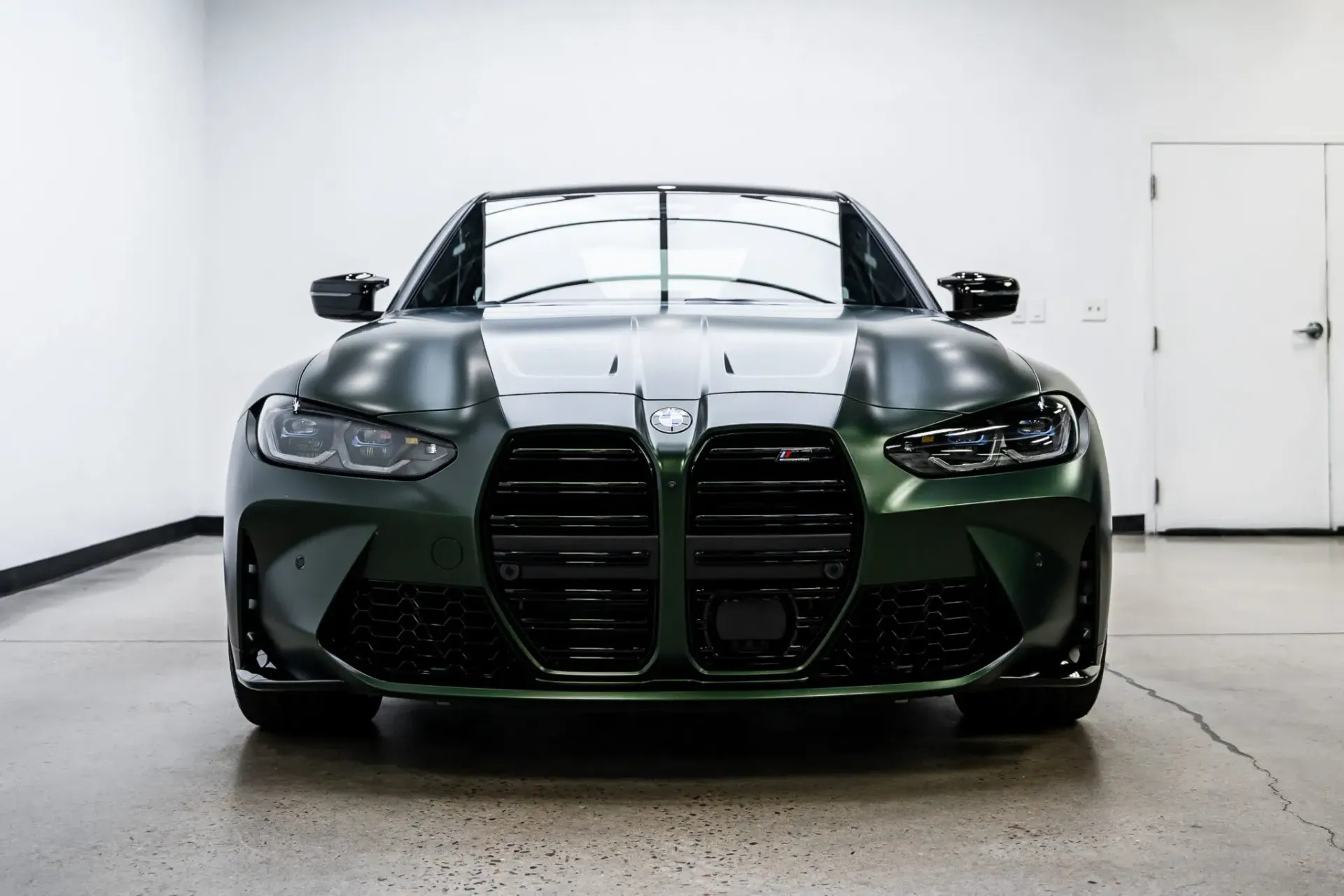 A green bmw m3 is parked in a garage.