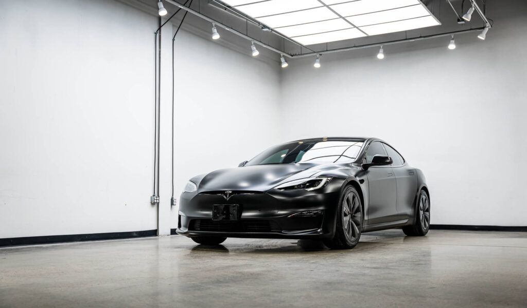 A tesla model s is parked in a garage.