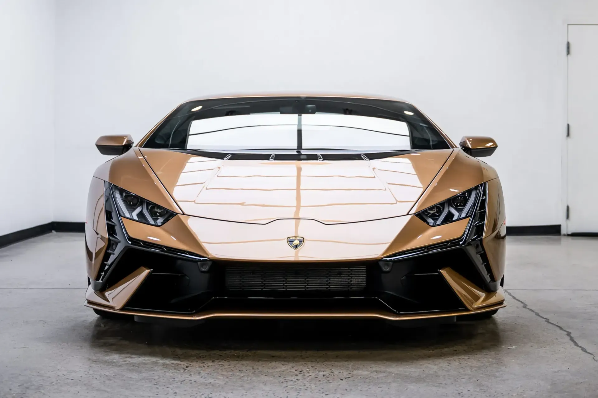 A gold lamborghini is parked in a garage.