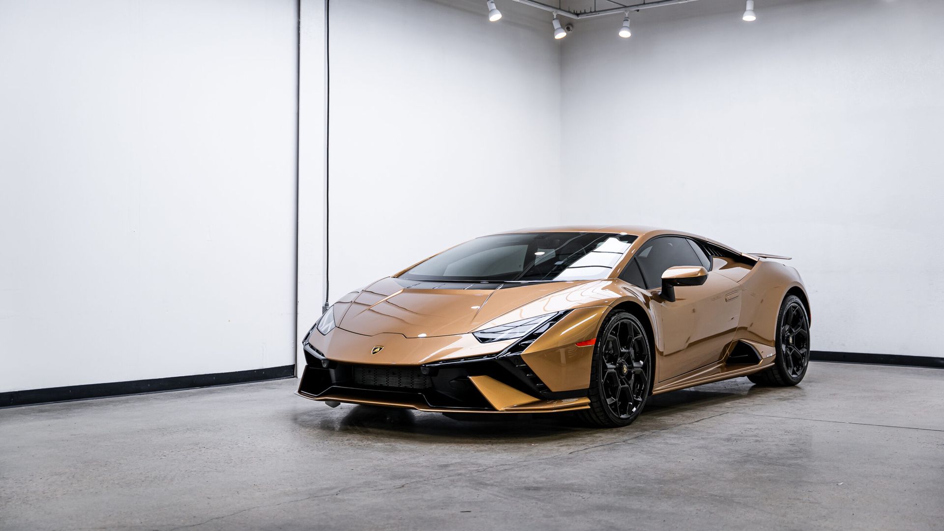 A gold lamborghini huracan is parked in a garage.